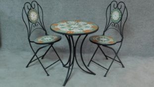 A pair of wrought iron mosaic inlaid garden chairs and a matching garden table. H.70 W.61 D.61cm (