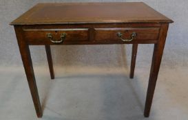A mid 20th century oak writing table with tooled leather inset top and two frieze drawers. SH.76 W.