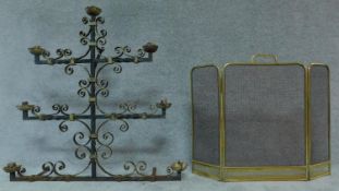 A Victorian wrought iron menorah together with a Victorian brass fire guard. H.96cm (Menorah)