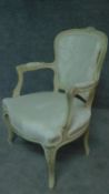 A carved and painted fauteuil in ivory damask on cabriole supports. H.86cm