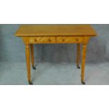 A Victorian satin birch writing table by Holland and Son with two frieze drawers on turned