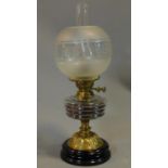 A late Victorian oil lamp with etched glass shade and brass base on turned ebonised socle. H.55cm