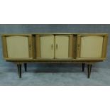 A vintage 1960's sideboard by Stonehill Furniture fitted four doors enclosing drawers on tapering