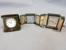 Three vintage travel clocks in gilded leather cases, silver plated and brass