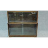 A mid 20th century two section bookcase by Minty, (makers label to the inside). fitted glass sliding