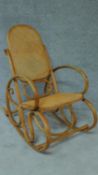 A Thonet style bentwood rocking armchair with caned back and seat. H.97cm
