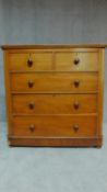 A Victorian mahogany chest of two short over three long drawers on plinth base and squat bun feet.