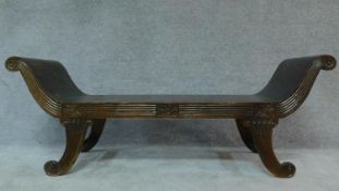 A Regency style scroll end window seat on swept reeded supports. H.160 W.63cm