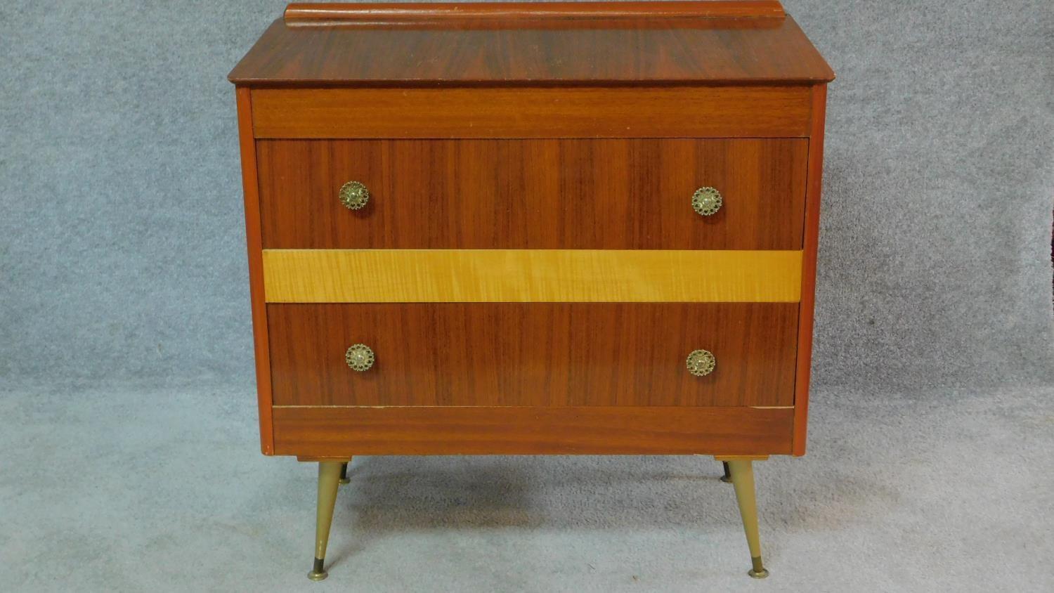 A vintage 1960's teak and satin birch inlaid chest of two long drawers on sputnik style supports.