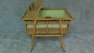 A wicker childs crib on stand fitted with casters. H.75 W.95 D.61cm