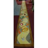 An extremely long runner, polychrome abstract decoration, inset brass and mesh panels. 93x1300cm