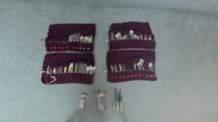 Five sets of silver plated cutlery in cloth roll cases. Each case has partitions for cutlery to be