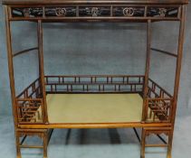 A Chinese hardwood four poster bedframe with woven base and pierced fretwork canopy. H.201 W.105 D.