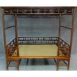 A Chinese hardwood four poster bedframe with woven base and pierced fretwork canopy. H.201 W.105 D.
