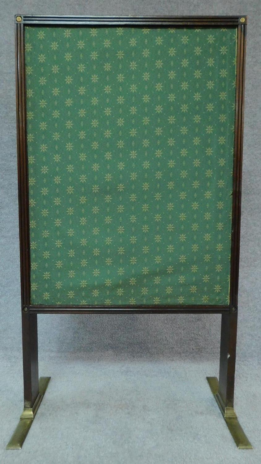 A Regency mahogany fire screen with sliding panels and central glazed drop in section on brass