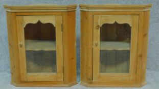 A pair of pine glazed door hanging corner cabinets. H.61 W.53 D.30cm
