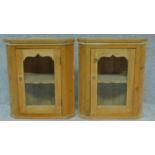 A pair of pine glazed door hanging corner cabinets. H.61 W.53 D.30cm