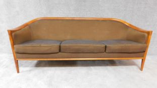 A mid 20th century Danish teak three seater sofa in tobacco calico upholstery. H. 71cm W. 197cm D.