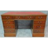 A Georgian style mahogany pedestal desk with red tooled leather inset top and arrangement of nine