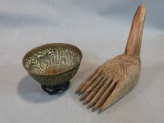 A tribal wooden foot carving and an Indian brass bowl with repousse animal design and a wooden stand