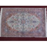 A Persian hand woven Mahal style rug with central medallion on an ivory and terracotta field with