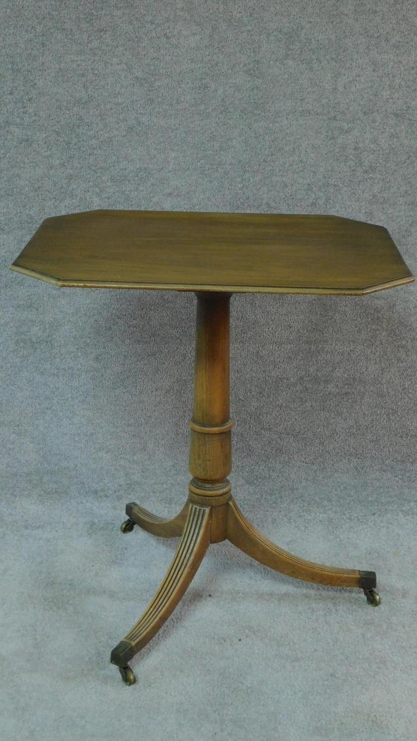 A Regency mahogany centre table with shaped octagonal top on turned column and swept reeded tripod