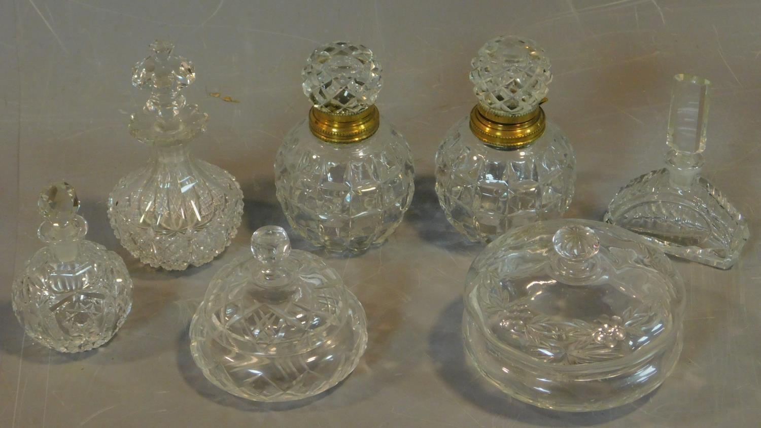 A pair of cut crystal scent bottles with gilt metal collars and a collection of other similar items.