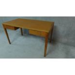 A mid 20th century oak two drawer writing table on square tapering supports. H.77cm W.137cm D.76cm