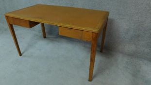 A mid 20th century oak two drawer writing table on square tapering supports. H.77cm W.137cm D.76cm