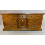 A French provincial style oak sideboard fitted with an arrangement of drawers and a central cupboard