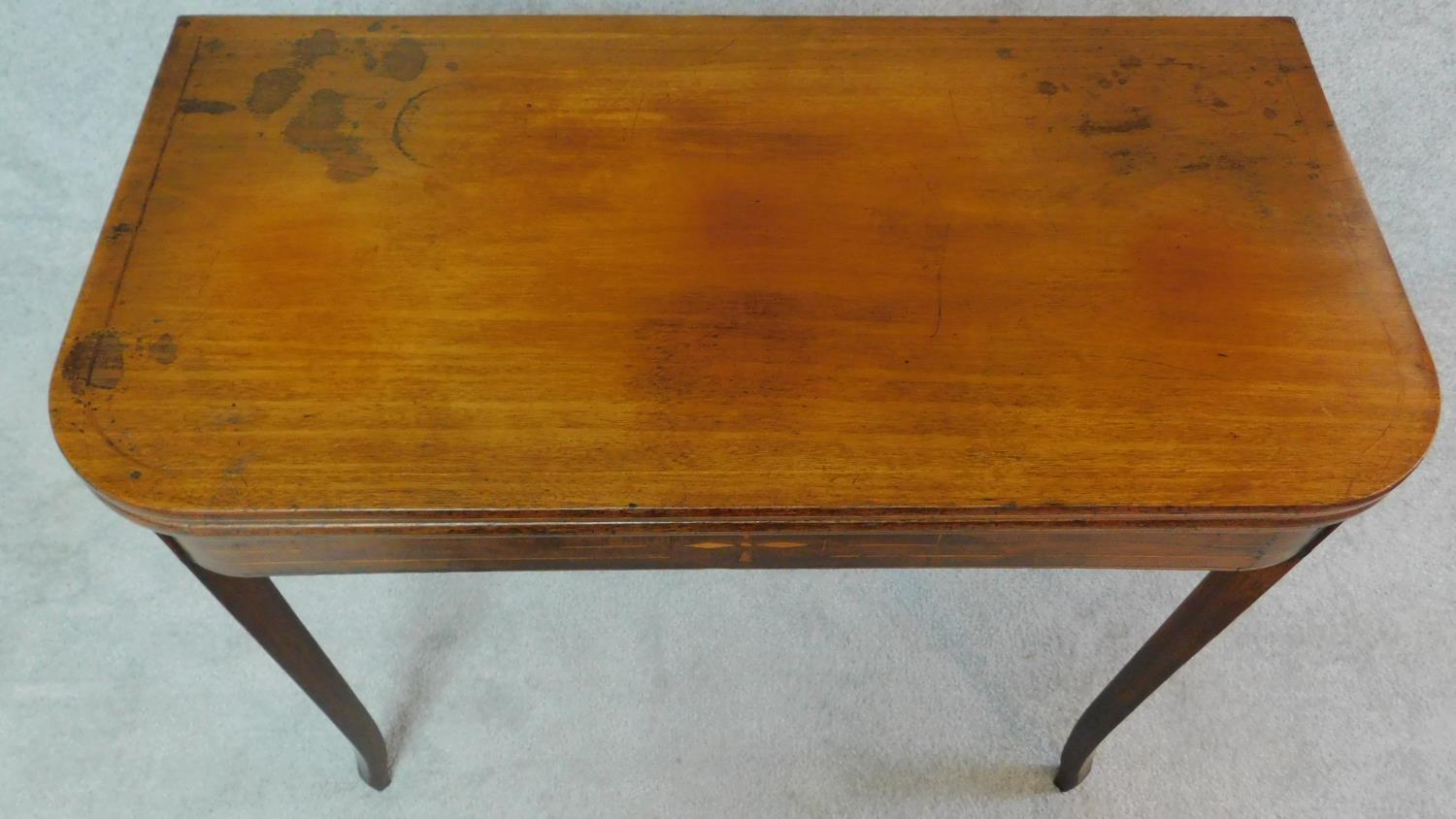 An early 19th century mahogany inlaid flap top tea table on tapering sabre supports. H.72 W.90 D.91 - Image 4 of 6