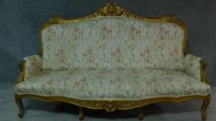 A 19th century rococo style giltwood three seat canape with shell carved cresting back rail and