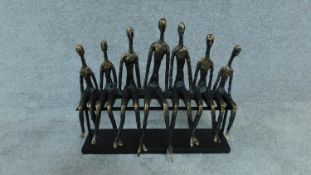 A moulded figure group, a row of figures on a bench, Giacometti style H. 36 W. 39