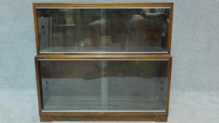 A mid 20th century two section bookcase by Minty, (makers label to the inside). fitted glass sliding