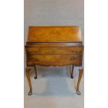 A mid Georgian style burr walnut bureau with fall front enclosing a fitted interior on cabriole