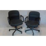 A pair of black upholstered swivel office desk chairs. H.90cm