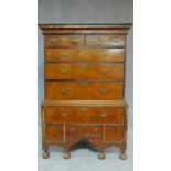 An early 18th century walnut, crossbanded and featherbanded chest on chest, the upper section with