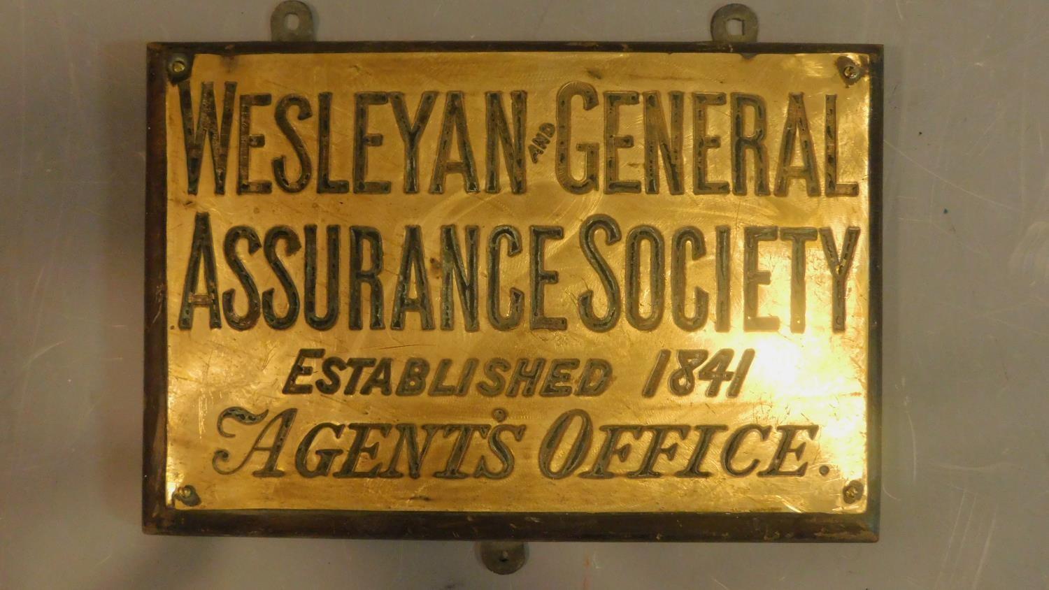 A collection of three brass wall plates for the Weslyan and General Assurance society.