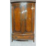 An early 20th century Georgian style mahogany bowfronted wardrobe fitted base drawer on swept