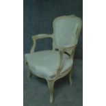 A carved and painted fauteuil in ivory damask on cabriole supports. H.86cm