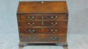 A Georgian Cuban mahogany bureau with fall front revealing fitted interior above four long drawers