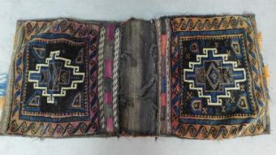 A pair of embroidered kelim saddlebags with abstract geometric design and a similar squab cushion.