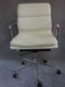 An Eames style swivel armchair in cream leather upholstery. H.96