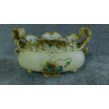 A porcelain hand painted poppy vase with two handles of foliate form with gilded outlines and