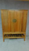 A Chinese teak marriage cabinet with folding panel doors on block stretchered supports H.69cm W.