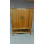 A Chinese teak marriage cabinet with folding panel doors on block stretchered supports H.69cm W.