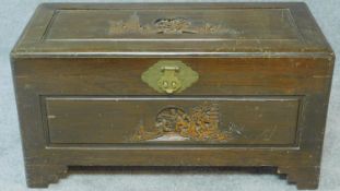 A Chinese carved teak chest with carved panels and inset carrying handles. H.40 W.76 D.36cm