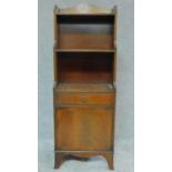 A small Regency style mahogany waterfall open bookcase fitted drawer and cupboard to base on splay