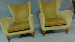 A pair of vintage gold velour wingback armchairs on squat beech cabriole supports. H.94cm