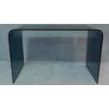A contemporary design curved smoked glass desk from a single heavy sheet with chamfered polished